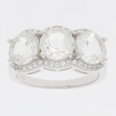 Round white Moissanite sterling silver ring with three sparkling stones and accent diamonds.